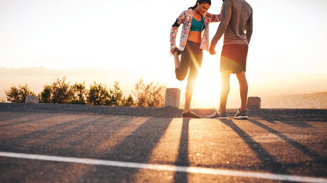 Runner-couple-sunset τελευταίος έλεγχος πριν τον αγώνα