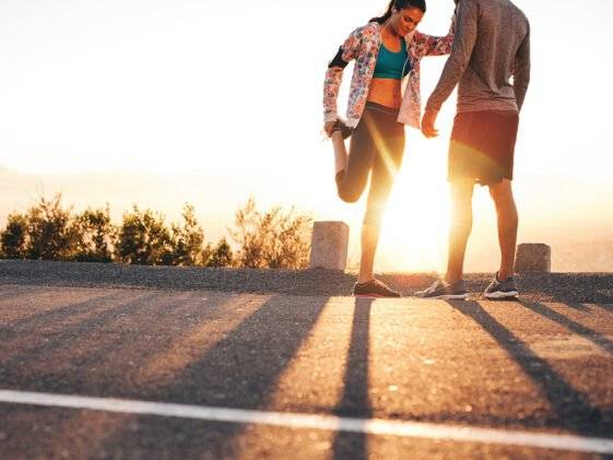 Runner-couple-sunset τελευταίος έλεγχος πριν τον αγώνα